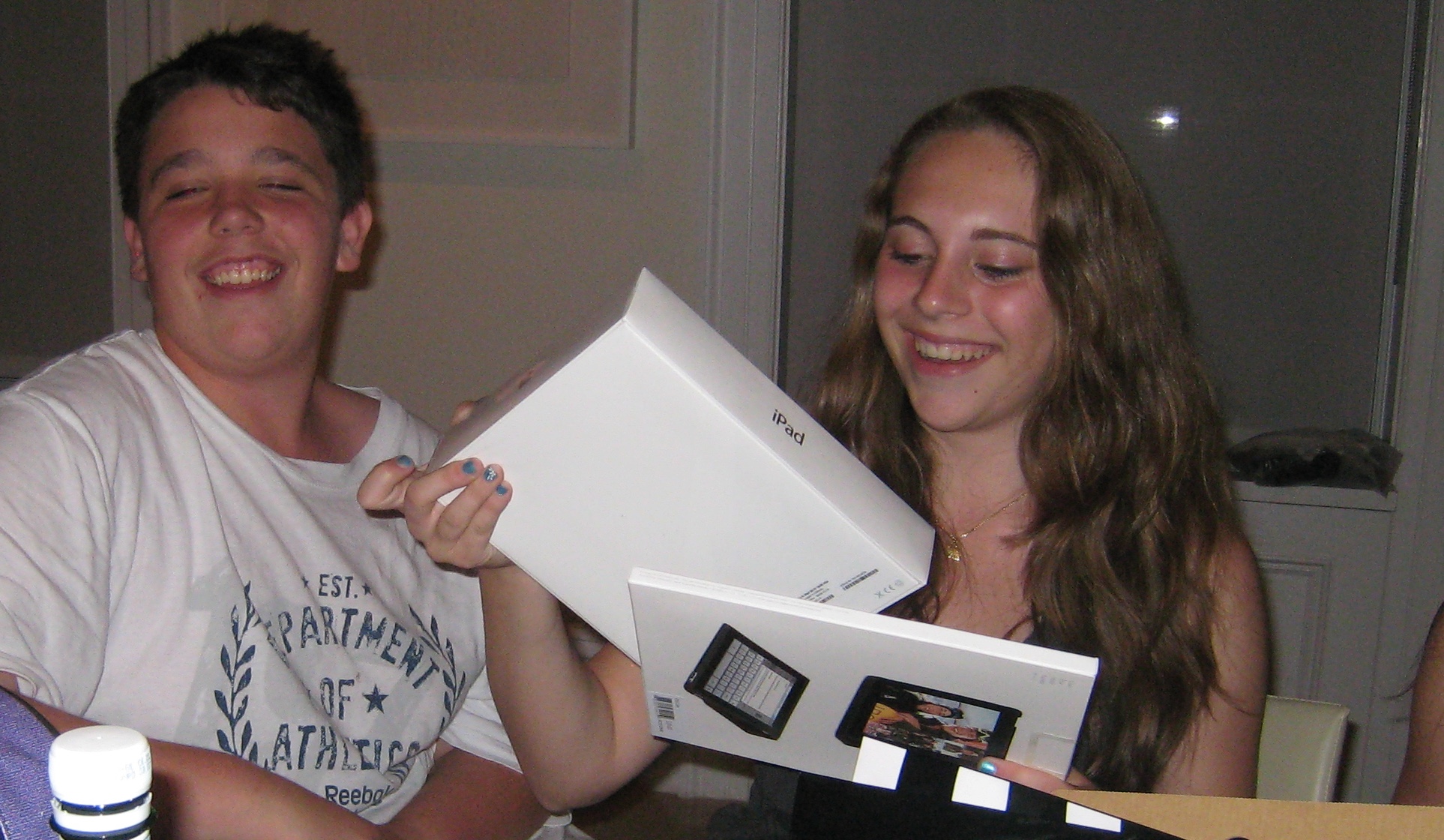 Morgan and Julia laughing as they unbox an iPad