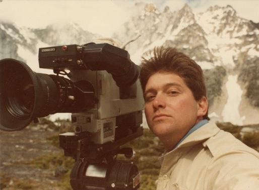 Ross with a large broadcast camera in a mountain landscape
