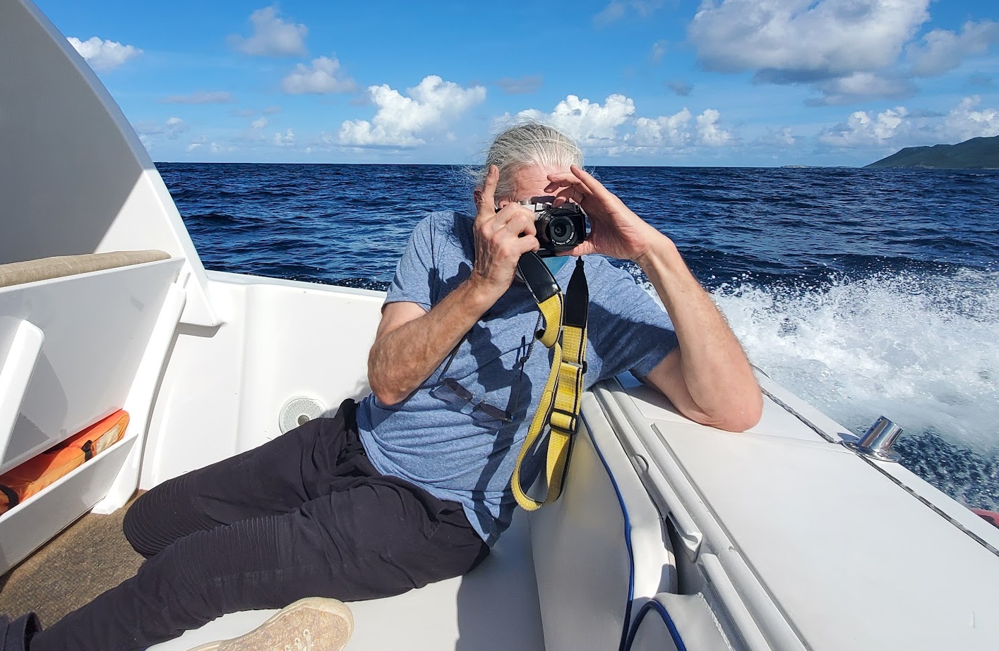 Ross photographing from the back of a boat on open water