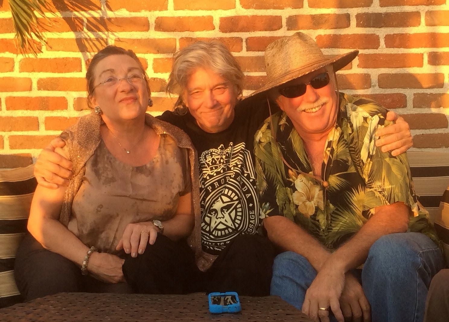 Three friends smiling together in the warm Baja sunlight